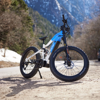 Cyrusher Trident e-bike parked on a scenic mountain trail with snow and trees in the background