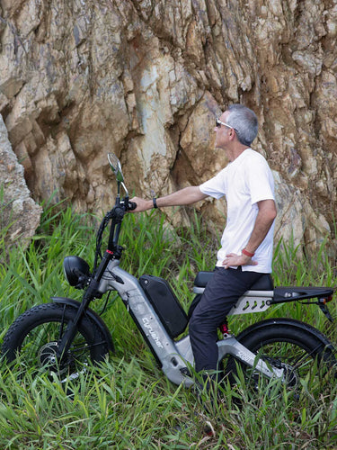 Man riding a Cyrusher Scout electric bike in a rocky grassland area