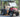 TrailMaster Taurus 50EV 4-seat electric golf cart with aluminum wheels, off-road tires, LED lights, and turn signals parked outdoors.