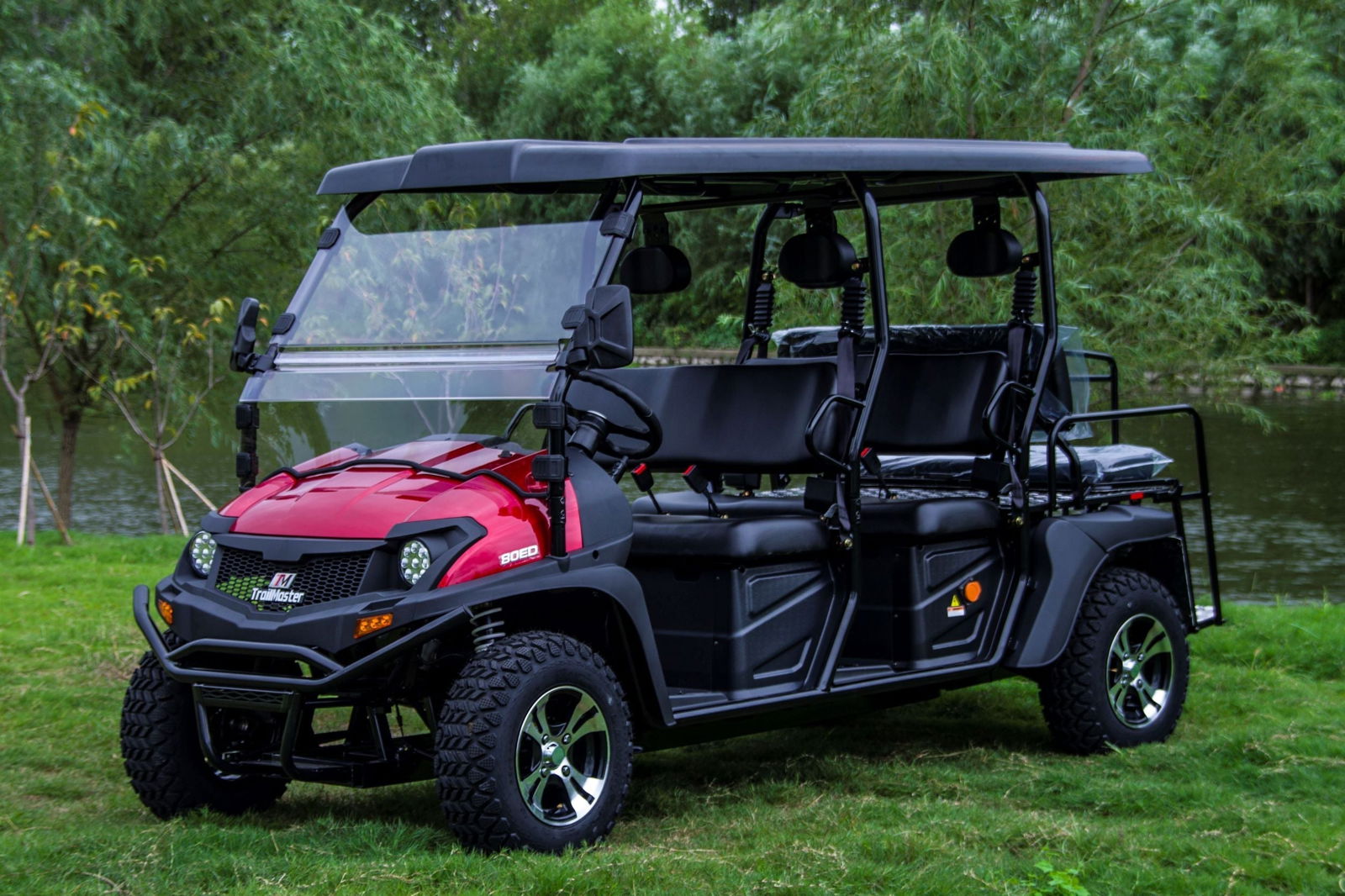 TrailMaster Taurus 80ED-GV 6-seat electric golf cart with extended roof and versatile rear seat for cargo, parked outdoors.