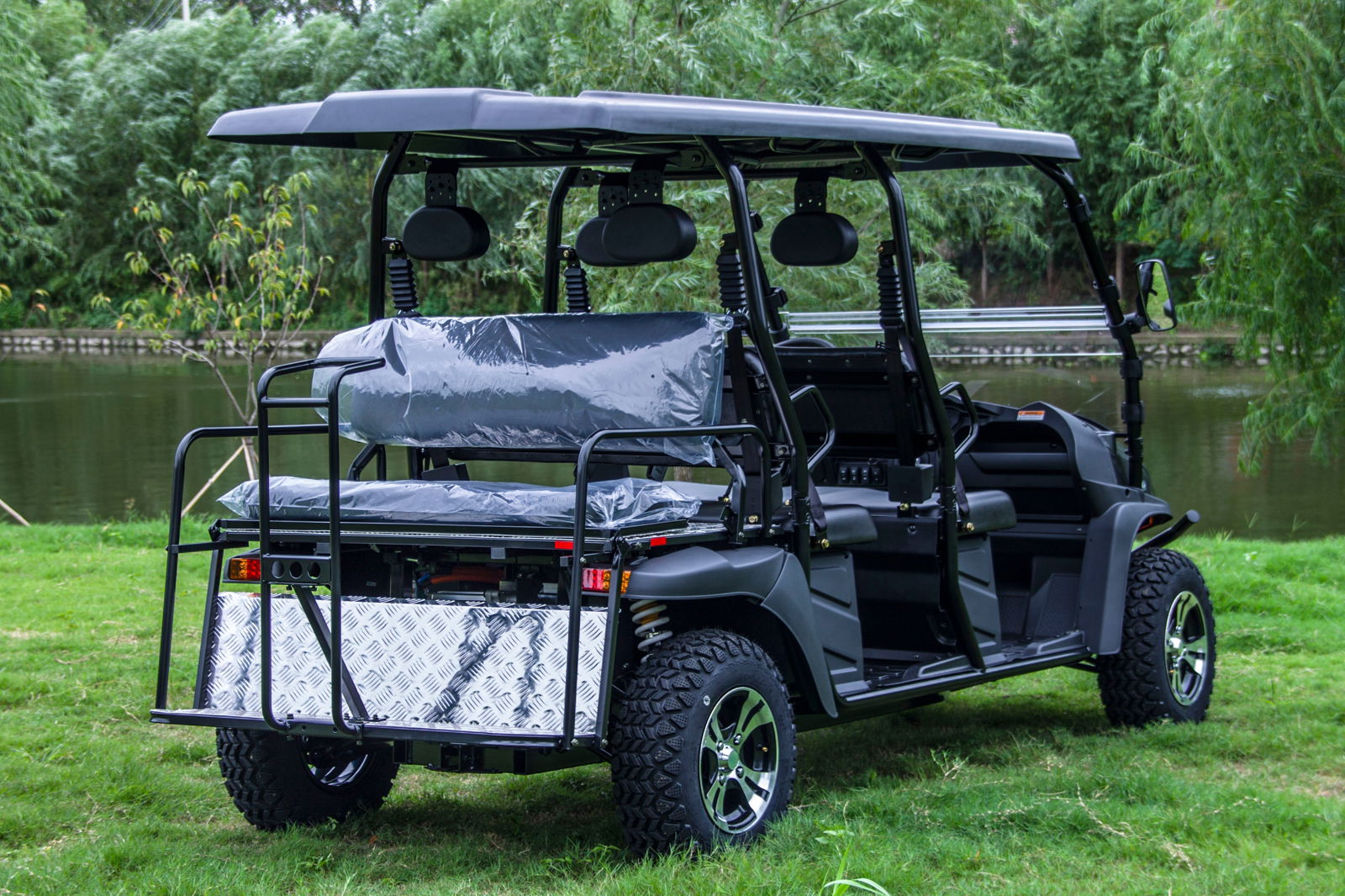TrailMaster Taurus 80ED-GV Electric Golf Cart with extended roof, showcasing versatile seating and cargo capacity on grassy field.