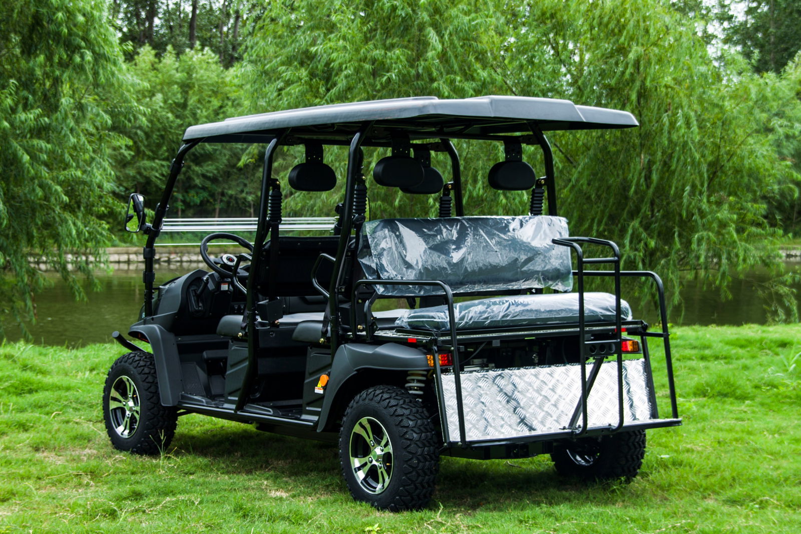 TrailMaster Taurus 80ED-GV 6-seat electric golf cart with extended roof, parked outdoors in a grassy area, showcasing rear-facing seats.