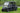 TrailMaster Taurus 80ED-GV 6-seat electric golf cart with an extended roof on grass, showing front and side views