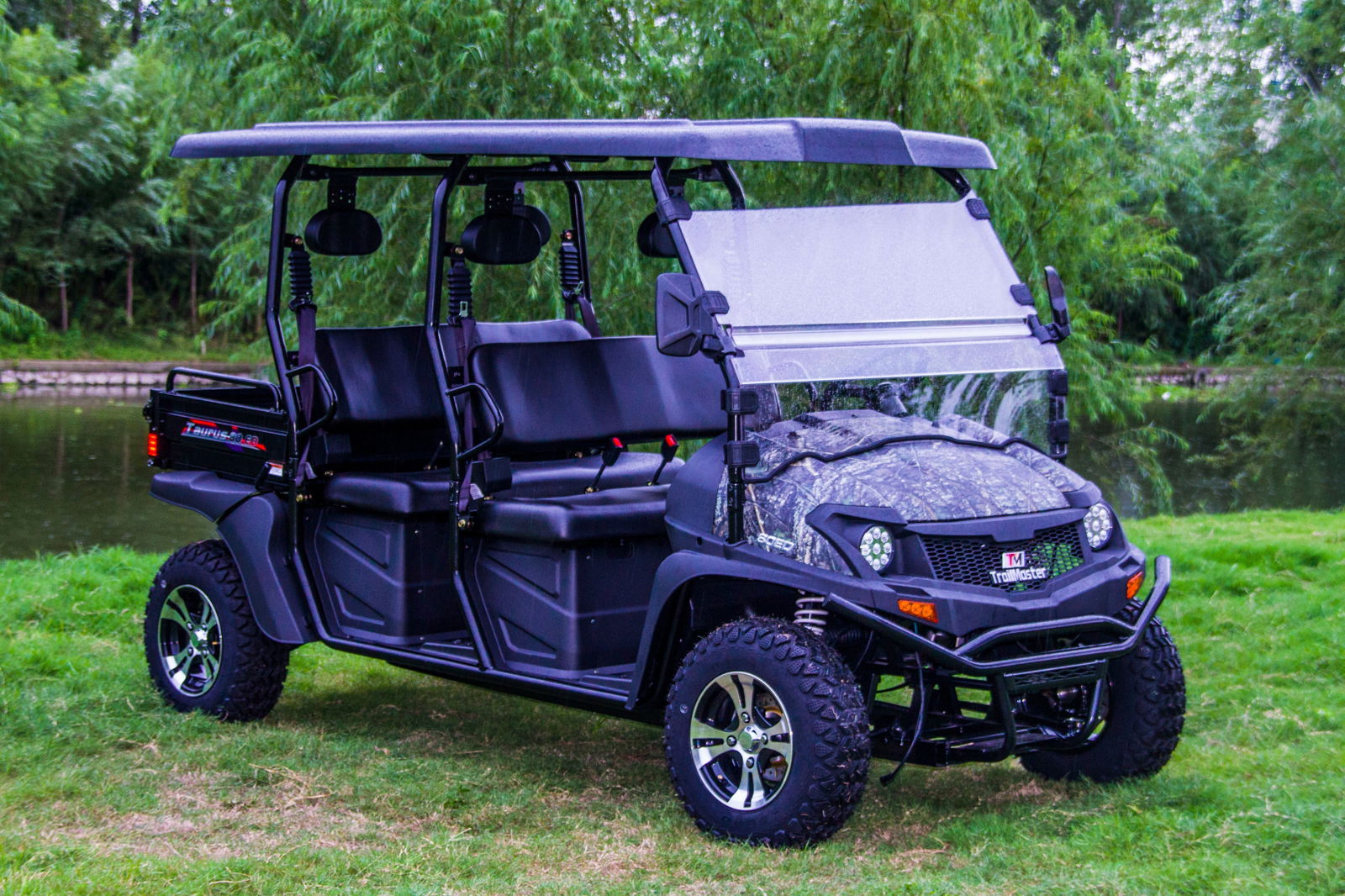TrailMaster Taurus 80ED-U 4-seat electric golf cart with dump bed and aluminum alloy wheels in outdoor setting.