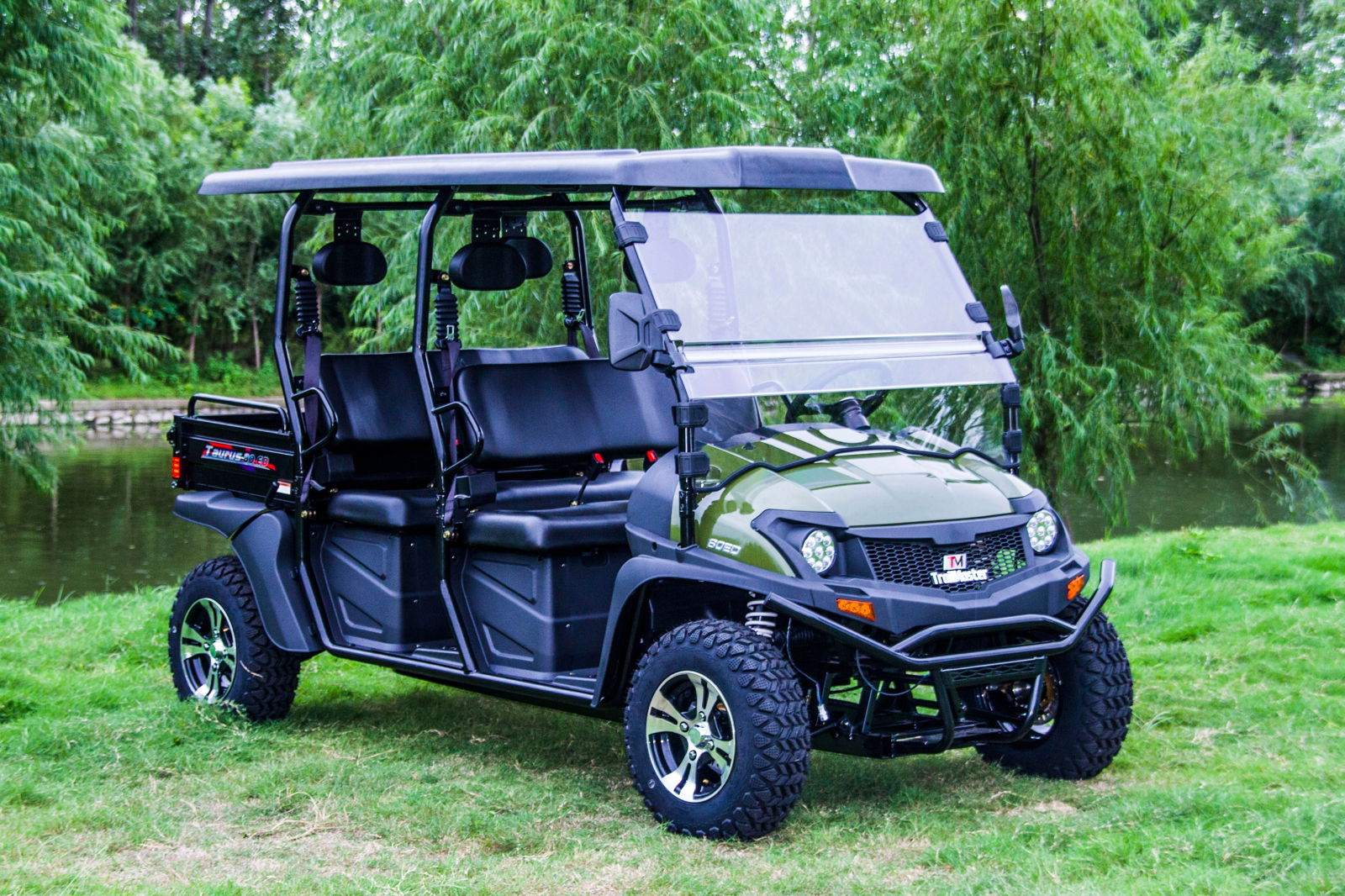TrailMaster Taurus 80ED-U 4-Seat Electric Golf Cart with dump bed, aluminum alloy wheels, and off-road tires, parked on grass.
