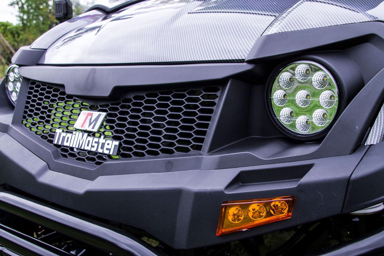 Close-up of TrailMaster Taurus 80ED-U 4-seat electric golf cart's front grille and LED headlights, showcasing modern design.