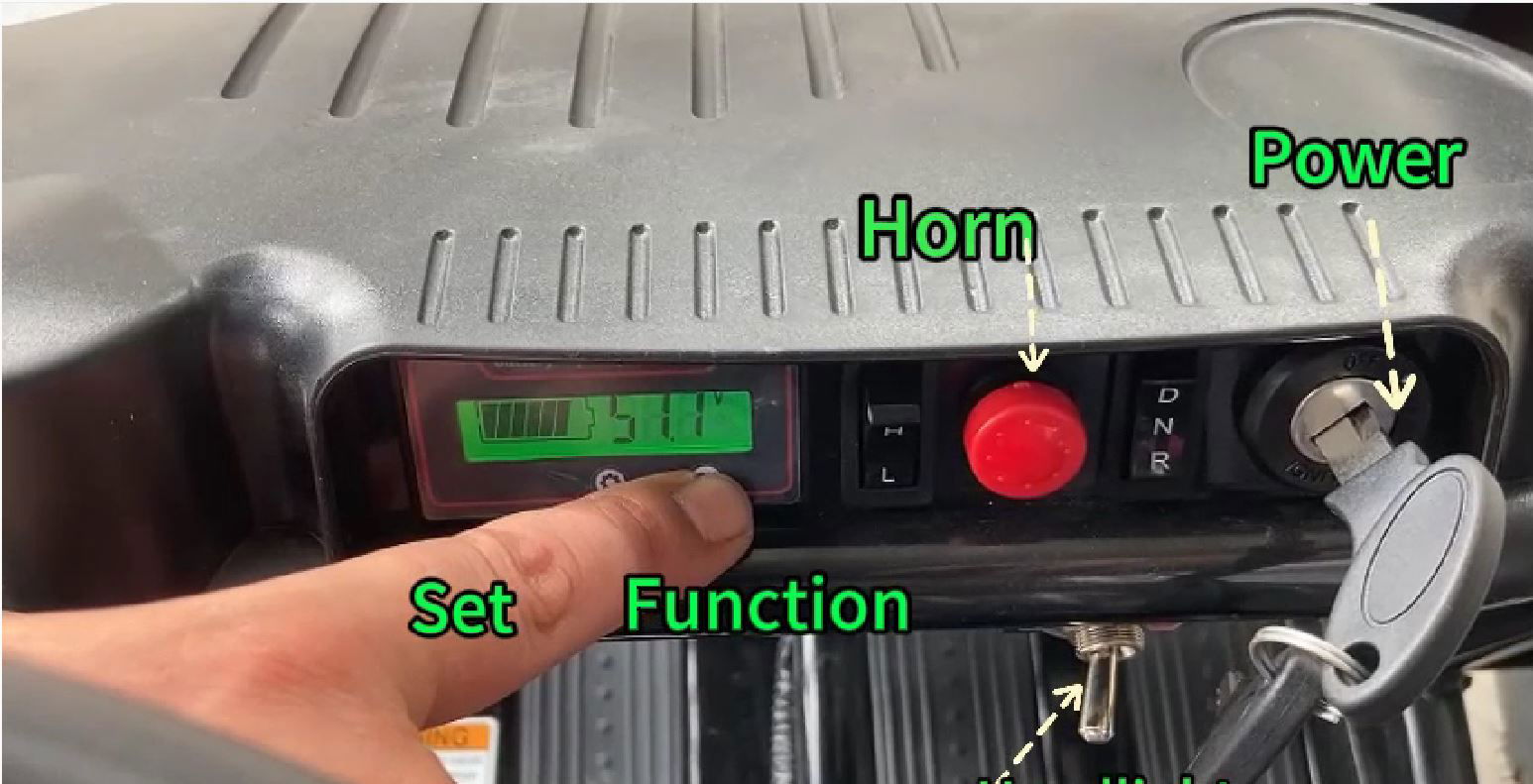 Control panel of the TrailMaster iMini Kids Electric Go Kart showing digital monitor, power, horn, and function settings.